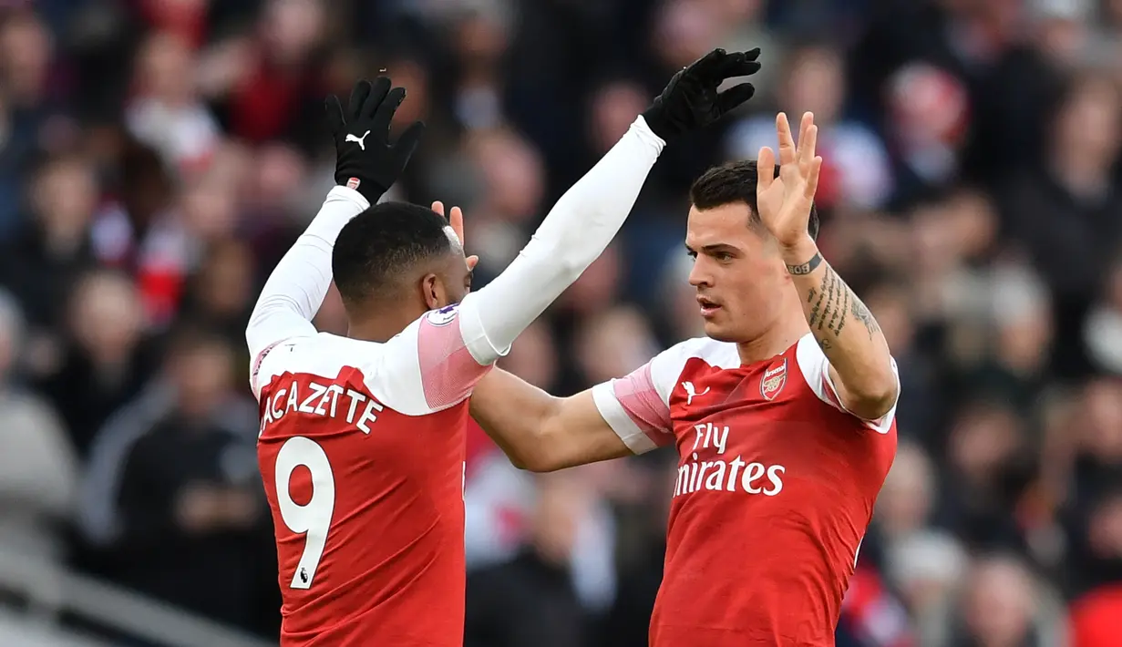 Selebrasi Granit Xhaka atas gol pertama Arsenal pada laga lanjutan Premier League yang berlangsung di Stadion Emirates, London, Minggu (10/3). Arsenal menang 2-0 atas Man United. (AFP/Ben Stansall)