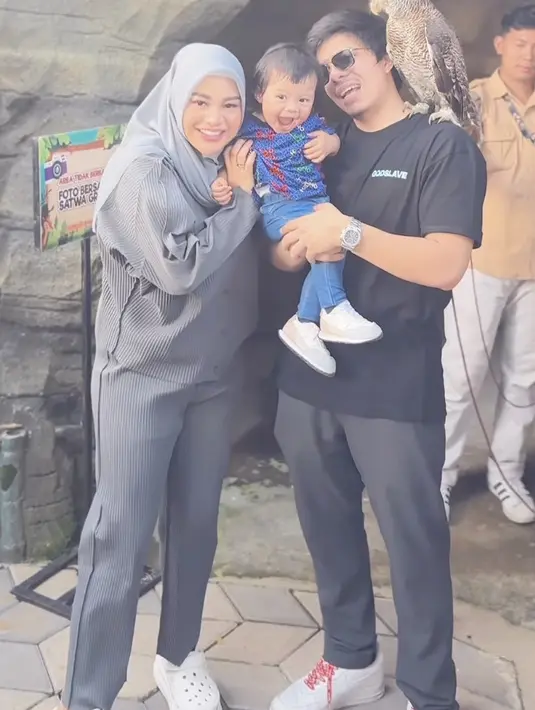 Aurel Hermansyah dan Atta pun ikut pulang kampung ke Jember. Saat bermain di mini zoo, Aurel tampil dengan one set abu-abu model plisket dipadukan kerudung warna senada. Credit:  (@aurelie.hermansyah)