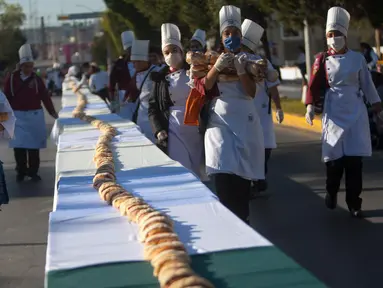 Suasana pembuatan kue raja sepanjang 2.063,43 meter di Saltillo, Negara Bagian Coahuila, Meksiko, 6 Januari 2019. Kue raja tersebut memecahkan Guinness World Record sebagai kue terpanjang di dunia. (Julio Cesar AGUILAR/AFP)