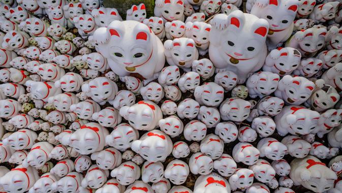 Patung-patung maneki-neko terlihat di Kuil Gotokuji, Tokyo, Jepang, Rabu (10/6/2020). Kuil Gotokuji terkenal karena dipercaya sebagai tempat kelahiran maneki-neko, kucing pembawa keberuntungan. (Philip FONG/AFP)