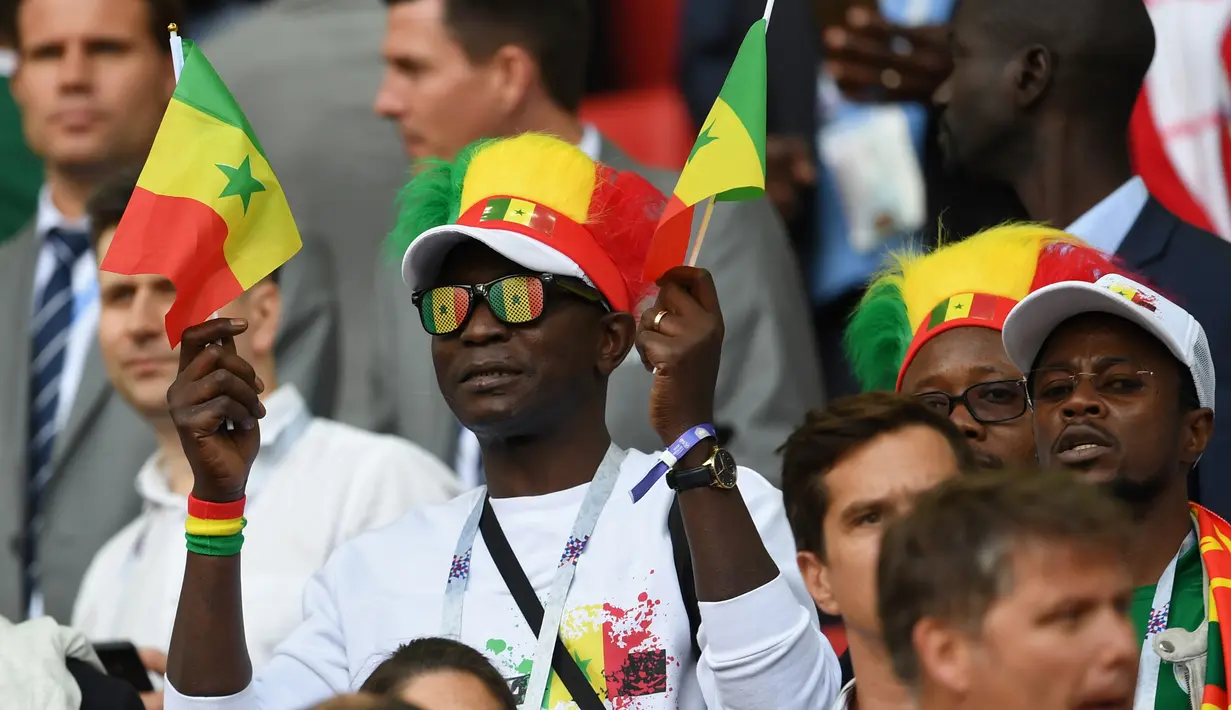 Suporter Senegal membawa bendera negaranya saat pertandingan melawan Polandia pada grup H Piala Dunia 2018 di Stadion Spartak di Moskow, Rusia (19/6). Dalam pertandingan ini Senegal menang 2-1 atas Polandia. (AFP Photo/Francisco Leong)