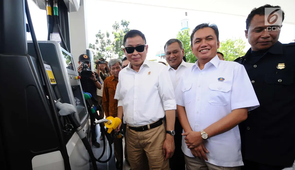 Menteri ESDM, Ignasius Jonan (kiri) mencoba selang pengisian BBM saat meninjau SPBU Vivo di kawasan Cilangkap, Jakarta, Kamis (26/10). SPBU tersebut akan menyalurkan BBM bensin RON 89, 90, dan 92 dengan merk Revvo. (Liputan6.com/Helmi Fithriansyah)