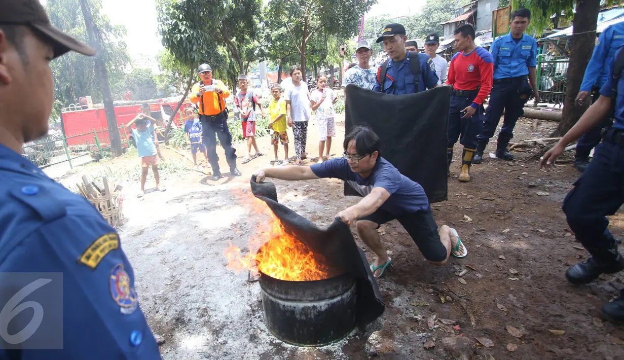 Warga mempraktekan cara mengantisipasi dini ketika terjadi kebakaran, Jakarta, Minggu (9/10). Kegiatan ini dilakukan untuk mengedukasi warga tentang bagaimana langkah awal yang dapat dilakukan saat terjadi kebakaran. (Liputan6.com/Immanuel Antonius)