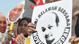 Aktivis menunjukkan poster Novel Baswedan saat menggelar aksi di depan gedung KPK, Jakarta (11/4). Mereka juga mendukung kpk untuk terus melanjutkan pengusutan kasus e-KTP sampai tuntas. (Liputan6.com/Helmi Afandi)