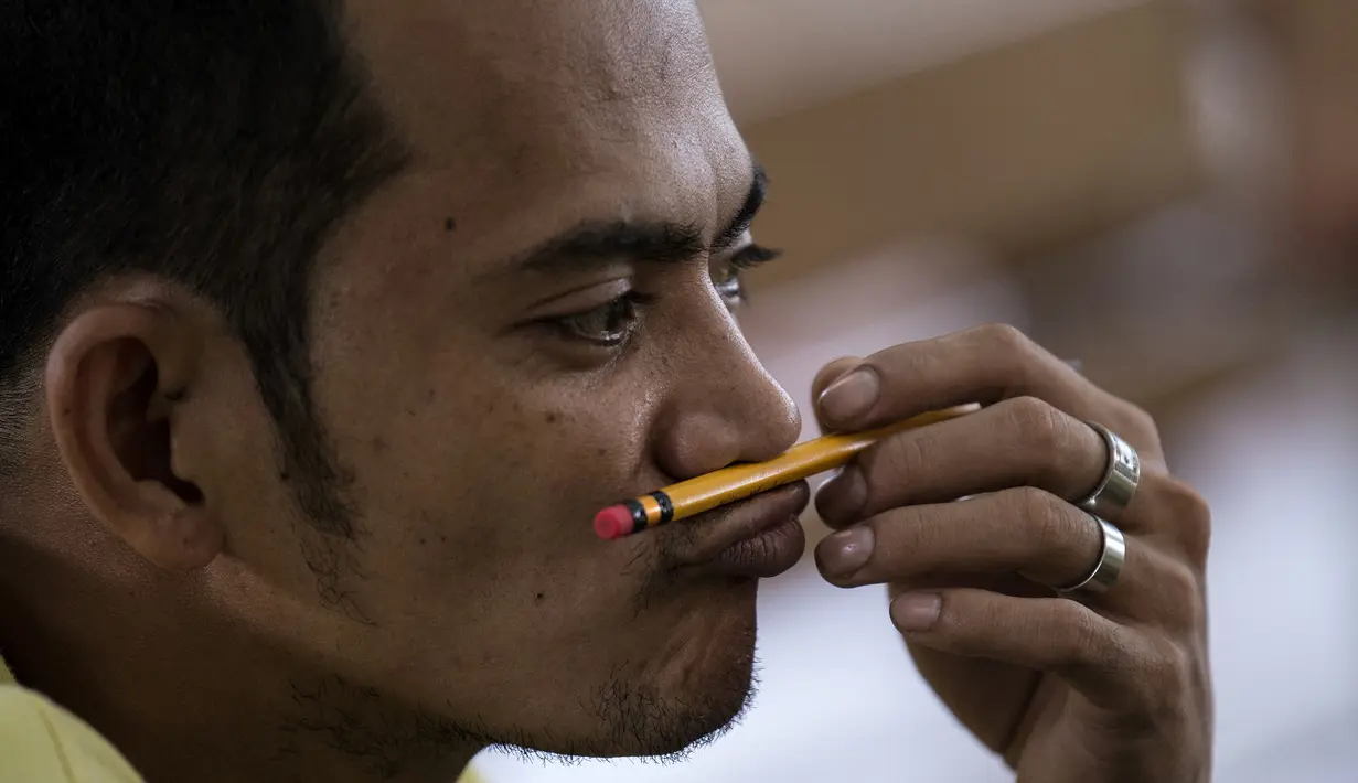 Narapidana memainkan pensilnya setelah mengikuti Ujian Akreditasi Nasional dan Pemeriksaan Kesetaraan di Penjara Manila City, Filipina, Minggu (19/11). Sekitar 900 napi, kebanyakan kasus narkoba, berpartisipasi dalam ujian SD dan SMA. (NOEL CELIS/AFP)