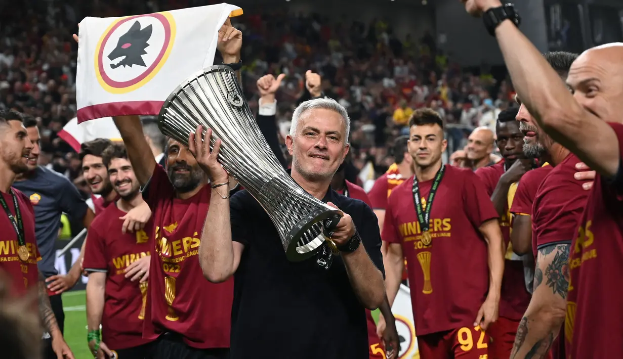Pelatih kepala AS Roma, Jose Mourinho mengangkat trofi EUFA Conference League setelah berhasil membawa AS Roma mengalahkan Feyenoord dengan skor 1-0 pada laga final yang berlangsung di Stadion Arena Kombetare Tirana, Albania, pada Kamis (26/5/2022) dini hari WIB. Bagi Mourinho, trofi ini menjadi gelar juara Eropa-nya yang kelima. (AFP/Ozan Kose)