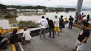 Beberapa warga berkerumun di tepi jembatan yang terputus akibat serangan topan Rammasun, di Batangas, Manila, (17/7/2014). (REUTERS/Erik De Castro)