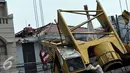 Pekerja mengevakuasi crane yang jatuh di Jalan Kyai Maja, Jakarta Selatan, Kamis (15/10/2015). Alat besar yang tengah melakukan proyek ‎jalan layang ini menimpa salah satu rumah warga yang berada di sisi kanan jalan. (Liputan6.com/Helmi Afandi)