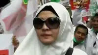 Peggy Melati Sukma berada di antara demonstran 4 November dengan mengenakan gamis panjang putih dan berkacamata hitam.