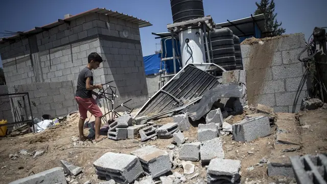 Seorang anak di Palestina melihat rumahnya yang hancur usai bentrokan Hamas dan Israel.
