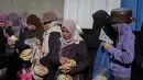 Penghalangan akses dan hambatan penyaluran bantuan ini jelas menghambat proses pemulihan situasi dan kondisi di Gaza. Tampak dalam foto, warga Palestina yang terlantar, anak-anak, dan dewasa, menunggu makanan di sebuah tempat penampungan yang telah dihuni keluarga-keluarga di Nuseirat, pusat Jalur Gaza, pada 23 November 2025. (EYAD BABA/AFP)