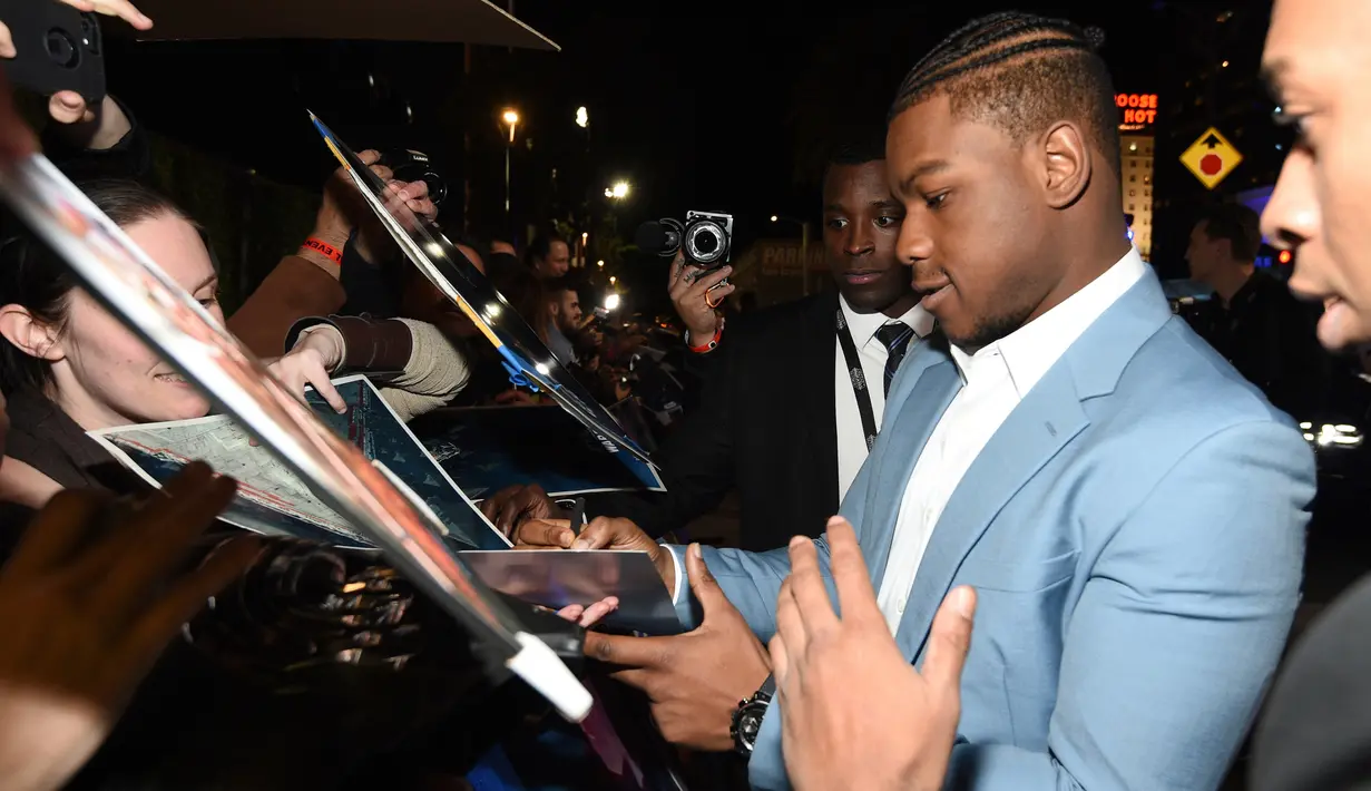 Aktor Inggris John Boyega memberikan tanda kepada penggemar saat menghadiri pemutaran perdana "Star Wars: The Rise Of Skywalker" di Hollywood, Senin (16/12/2019). Star Wars: The Rise of Skywalker merupakan film pemuncak dari trilogi Star Wars yang terbaru. (AP Photo/Chris Pizzello)