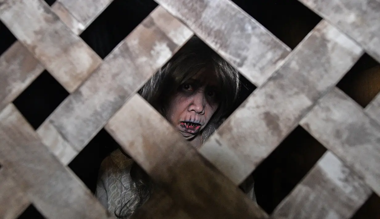 Seorang wanita mengenakan kostum menyeramkan saat preview media 'Halloween Horror Nights' di Universal Studio, Singapura, Senin (24/9). Kali ini Universal Studio Singapura mengusung tema Infinit Fear untuk menguji nyali pengunjung. (AFP/Roslan RAHMAN)