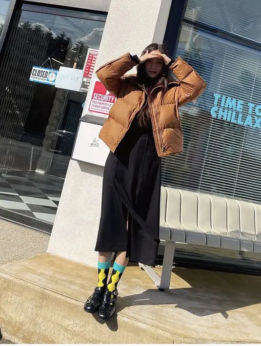 Short padding cokelat dipadukan dress hitam juga membuatnya tampil stylish. Dengan kaos kaki colorfull dan sepatu oxford hitamnya. (@hyominnn)