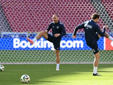 Gelandang Denmark #10 Christian Eriksen (kiri tengah) melakukan pemanasan selama sesi Latihan utnuk turnamen EURO 2024 di Stuttgart Arena, Jerman, Sabtu (15/6/2024). (THOMAS KIENZLE / AFP)