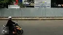 Seorang wanita mengendarai motor melewati depan Pasar Kramatjati yang  mengalami revitalisasi di Jakarta, Jumat (23/10/2015). Pasar Kramatjati mulai direvitalisasi pada Juli lalu dan ditargetkan selesai hingga 18 bulan kedepan. (Liputan6.com/Yoppy renato)