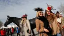 Dua wanita berpose di samping patung "Best Mate" saat orang-orang tiba pada hari pertama Festival Cheltenham di Cheltenham Racecourse, di Cheltenham, Inggris (15/3/2022). Kehadiran para wanita memberikan nuansa tersendiri di kompetisi pacuan kuda tersebut. (Mike Egerton/PA via AP)