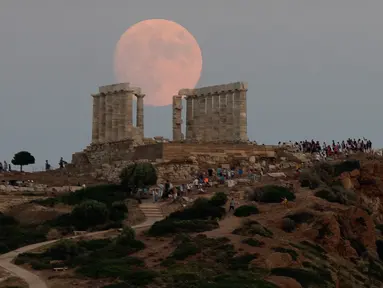 Bulan purnama hampir penuh yang menampakkan diri di langit Kuil Poseidon kuno di Cape Sounion, sekitar 70 kilometer sebelah tenggara Athena, Yunani (2/8/2020). (Xinhua/Marios Lolos)
