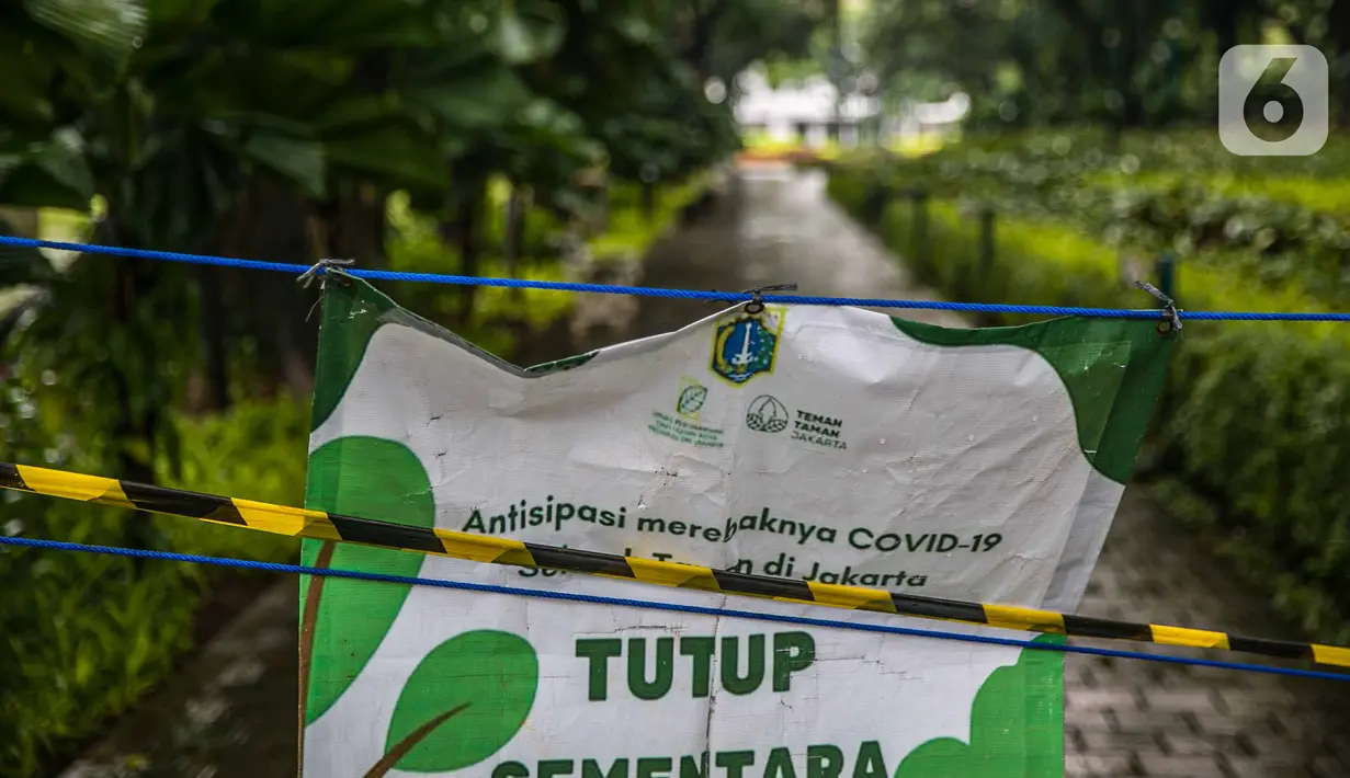 Spanduk penutupan dipasang di Taman Menteng, Jakarta, Kamis (31/12/2020). Pemprov DKI Jakarta mulai hari ini menutup sementara seluruh taman dan hutan kota di Ibu Kota jelang Tahun Baru 2021 untuk mengantisipasi penyebaran virus Covi-19. (Liputan6.com/Faizal Fanani)