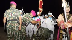 Komandan Korps Marinir (Dankormar) Mayjen TNI (Mar) Bambang Suswantono memakaikan baret kepada perwakilan Tamtama Remaja Marinir saat upacara Pembaretan di Pantai Nganteb, Malang Selatan, Jawa Timur, Kamis (12/4). (Liputan6.com/Pool/Marinir TNI-AL)