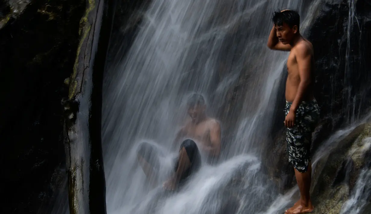 Anak-anak muda perempuan menikmati air terjun di Samadua, Provinsi Aceh pada 9 Juli 2020. Aceh punya banyak destinasi wisata alam  mempesona yang patut dikunjungi. (Photo by CHAIDEER MAHYUDDIN / AFP)