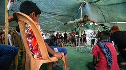 Rombongan badut Spanyol menghibur anak-anak Palestina di desa suku Bedouin, Tepi Barat yang diduduki, 22 September 2018. Atraksi ini dilakukan lantaran desa berpenduduk sekitar 180 orang itu akan digusur Israel pada Oktober mendatang. (AFP/ABBAS MOMANI)