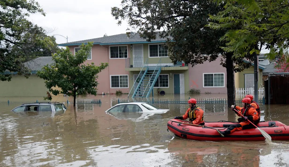 Tim SAR menggunakan perahu karet mencari warga yang terjebak banjir di San Jose, California, Selasa (21/2). Banjir terjadi akibat meluapnya Sungai Coyote Creek yang tidak mampu menampung debit air setelah hujan lebat. (AP Photo/Marcio Jose Sanchez)