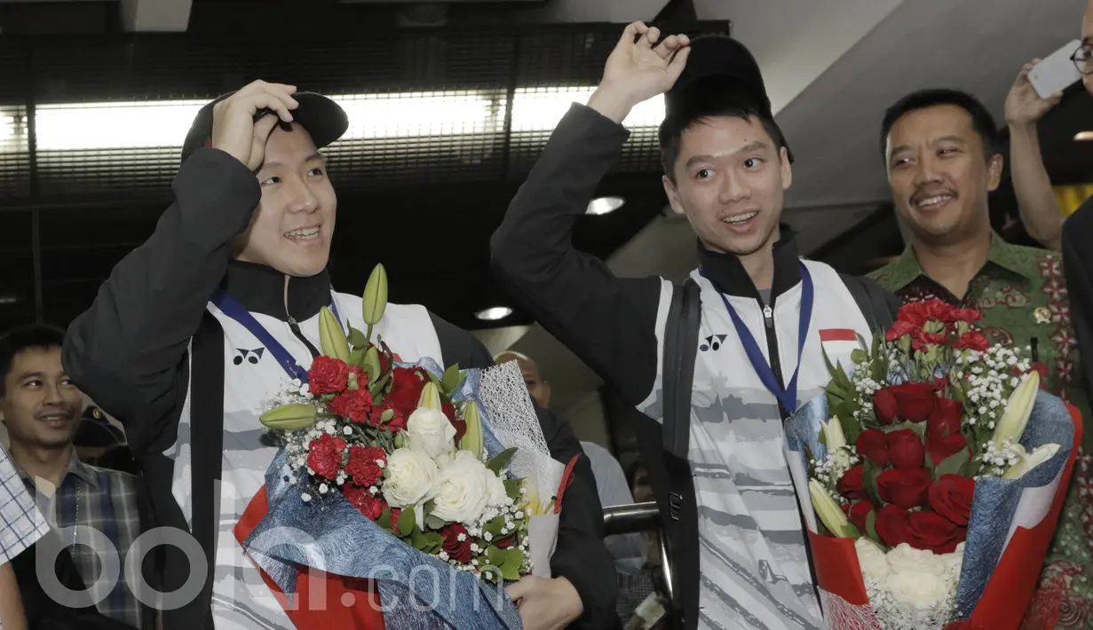 Pebulutangkis ganda putra Indonesia, Kevin Sanjaya/Marcus Gideon, mengangkat topi saat akan difoto. Pasangan ini menjadi satu-satu nya wakil Indonesia yang berhasil membawa pulang gelar All England tahun ini. (Bola.com/M Iqbal Ichsan)