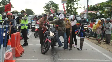 Pengemudi motor tampak menuntun kendaraannya di  jalan Lamaran, Karawang, Jawa Barat, Minggu (3/7).Kecelakaan kecil terjadi menimpa pemudik yang menggunakan sepeda motor di jalan Lamaran, Karawang. (Liputan6.com/Gempur M Surya)
