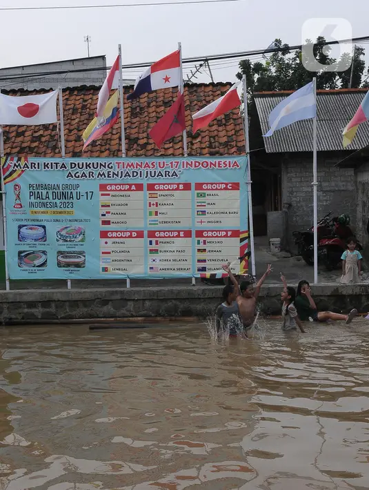 <p>Warga Kampung Asem memasang bendera negara peserta Piala Dunia U-17 2023. (merdeka.com/Imam Buhori)</p>