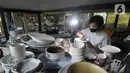 Perajin menyelesaikan pembuatan keramik secara handmade di Pekunden Pottery, Bojongsari, Depok, Jawa Barat, Rabu  (22/9/2021). Produksi keramik rumahan tersebut mampu bertahan di masa pandemi dengan mengandalkan jaringan offline dari mulut ke mulut. (merdeka.com/Arie Basuki)