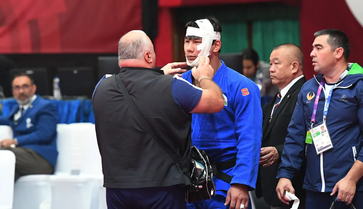 Pejudo putra Uzbekistan, Bekmurod Oltiboev mendapatkan perawatan medis saat melawan Takeshi Ojitani asal Jepang di permpat final judo Asian Games 2018 di Jakarta, Jumat (31/8). (ANTARA FOTO/INASGOC/Bram Selo Agung/18)