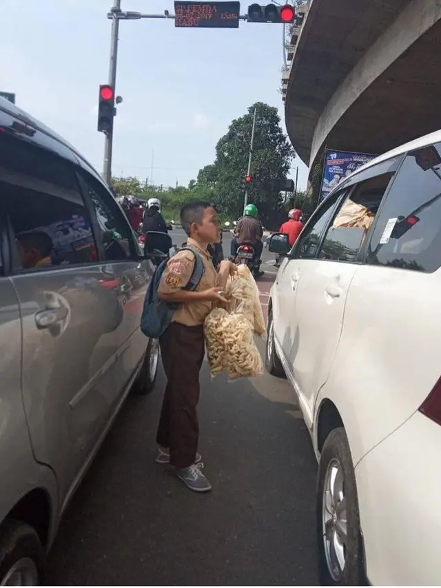 Demi Masa Depan, Bocah Berseragam Sekolah Nyambi Jualan di Lampu Merah
