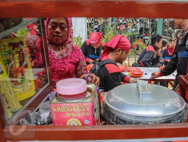 Buruh beristirahat sambil makan siang disela aksi demo di kawasan Istana Negara, Jakarta, Kamis (15/9). Ribuan buruh dari berbagai elemen organisasi menyatakan penolakan mereka terhadap paket kebijakan ekonomi jilid IV. (Liputan6.com/Faizal Fanani)