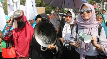 Sejumlah ibu-ibu yang tergabung dalam Barisan Emak-Emak Militan (BE2M) Indonesia menggelar aksi di seberang Istana Merdeka, Jakarta, Rabu (18/7). Mereka menuntut Presiden Jokowi menurunkan harga sembilan bahan pokok (sembako). (Liputan6.com/Arya Manggala)