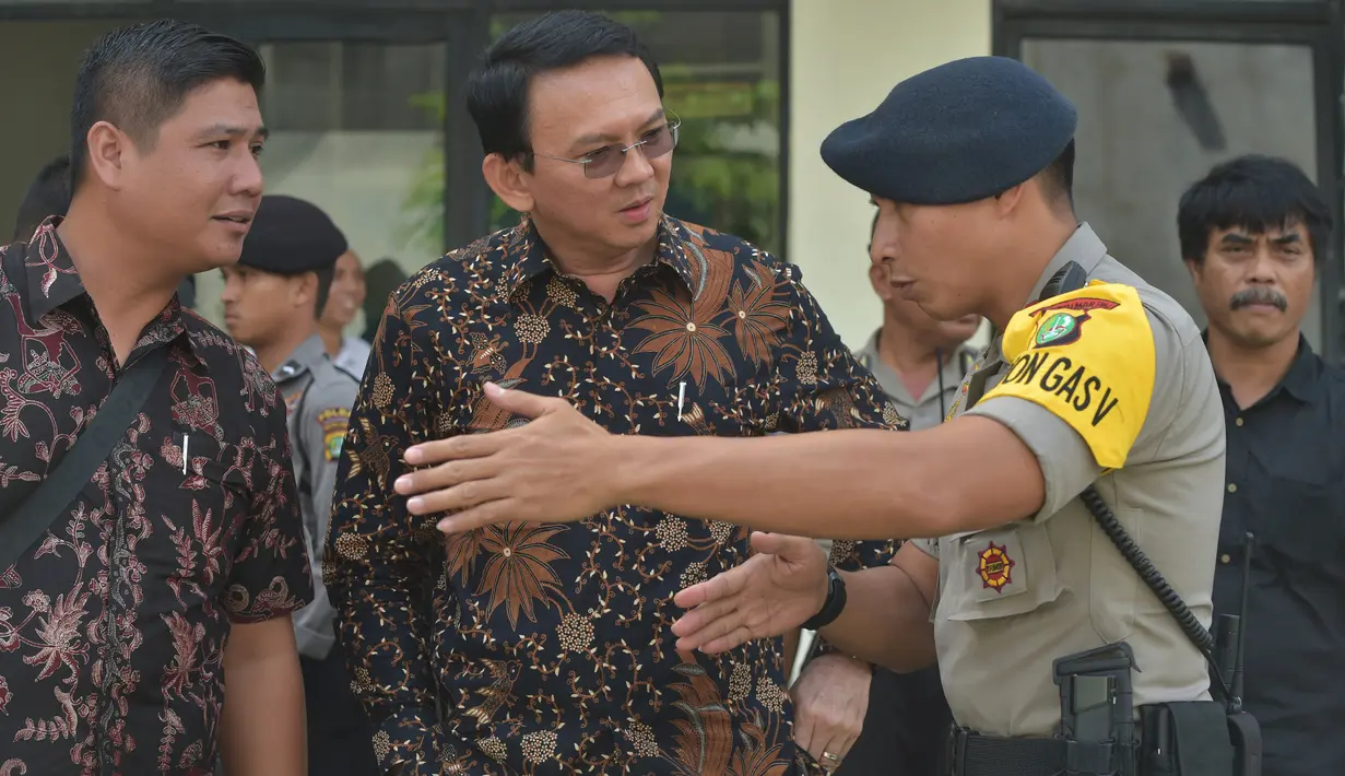 Gubernur DKI Jakarta nonaktif, Basuki Tjahaja Purnama (Ahok) mendengarkan penjelasan seorang polisi terkait rencana meninggalkan PN Jakarta Utara, Selasa (20/12). Sebelumnya Ahok menjalani sidang kedua kasus dugaan penistaan. (REUTERS/Adek BERRY/Pool)
