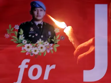 Foto multiple exposure menggambarkan peserta aksi yang menyalakan lilin dan spanduk bergambar Brigadir Novriansyah Joshua Hutabarat alias Brigadir J di kawasan Taman Ismail Marzuki (TIM), Jakarta, Senin (8/8/2022). Aksi tersebut bertajuk “Keadilan untuk Joshua! Aksi menyalakan 3000 lilin dan doa bersama mengenang kematian Brigadir J”. (Liputan6.com/Helmi Fithriansyah)