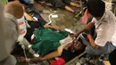 Seorang pria mendapat perawatan setelah menjadi korban dalam demonstrasi berujung ricuh di Pejompongan, Jakarta, Rabu (25/9/2019). Sebelumnya, ribuan pelajar yang melangsungkan demonstrasi di Gedung DPR terlibat bentrok dengan polisi. (Liputan6.com/Helmi Fithriansyah)