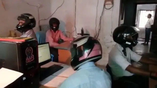 Para pekerja di Bihar menggunakan helm di kantor mereka pada tahun 2017.