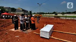 Keluarga korban mensalatkan jenazah untuk dimakamkan di lahan baru tempat pemakaman umum (TPU) khusus COVID-19, Jombang, Tangerang Selatan, Banten,Senin (26/7/2021). Pemkot Tangerang Selatan membuka lahan baru TPU khusus COVID-19 yang dapat menampung 800 makam. (merdeka.com/Arie Basuki)