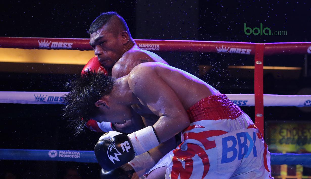 Petinju Indonesia, Jansen Marapu (kiri) melepaskan pukulan ke wajah Phuttiphong Rakoon pada kelas Lightweight Mahkota Boxing Super Series di Cilandak Town Square, Jakarta (10/3/2018). Jansen menang TKO pada ronde ke sembilan. (Bola.com/Nick Hanoatubun)