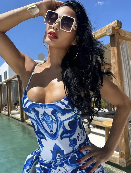 Perempuan yang kini berusia 39 tahun tersebut pun nampak percaya diri dengan baju renang bodysuit warna biru putih. Dipadukan kacamata dan aksesorinya.  (@indahkalalo)