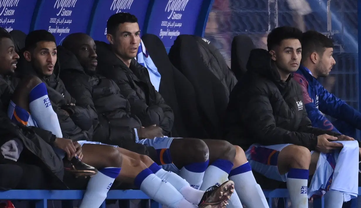 main depan Riyadh All-Star, Cristiano Ronaldo (tengah) melihat dari bangku cadangan selama pertandingan persahabatan melawan PSG di Stadion Universitas King Saud, di Riyadh, Arab Saudi, 19 Januari 2023. Pemain berusia 37 itu masih belum melakukan debut kompetitifnya bersama klub barunya Al Nassr setelah pindah pada awal tahun ini. (AFP/Fayez Nureldine)