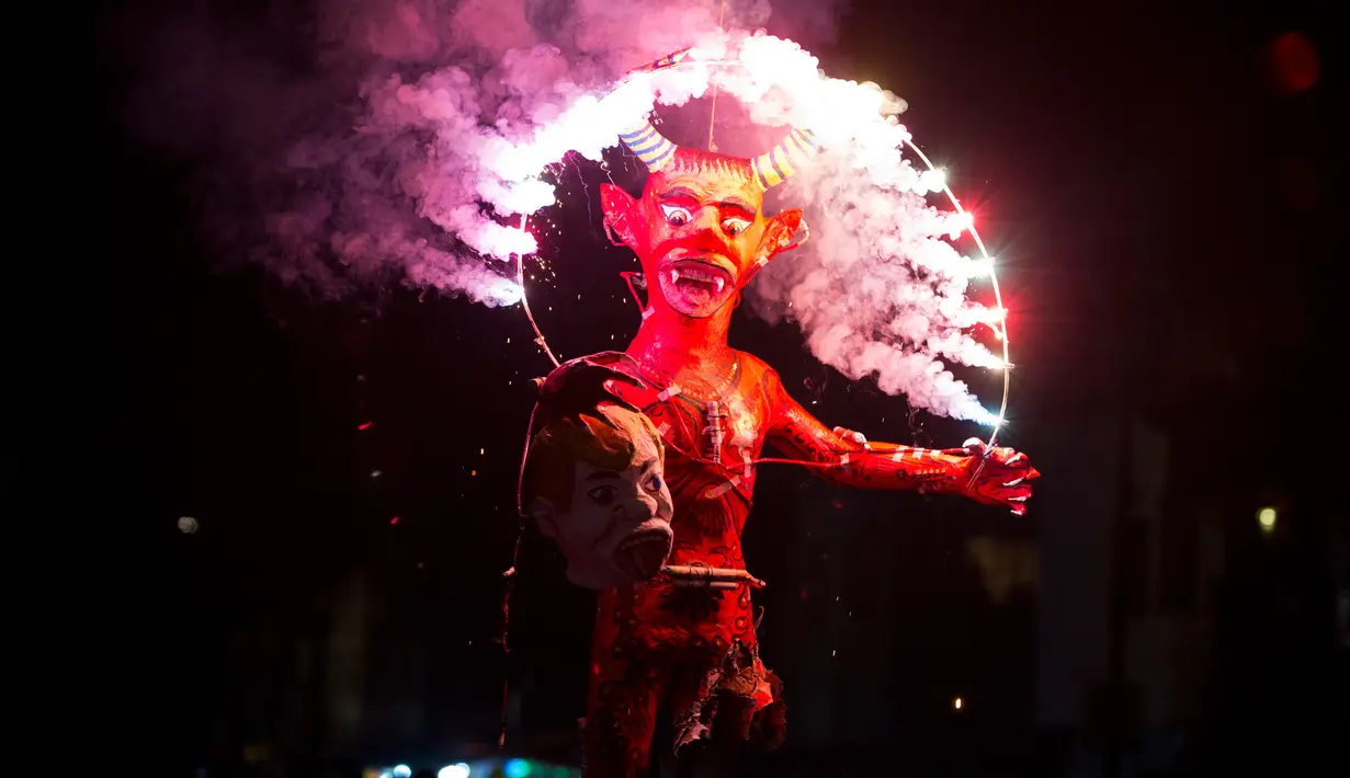 Kembang api meledak di patung setan yang memegang kepala Presiden AS Donald Trump saat perayaan pembakaran Yudas di Mexico City, Meksiko (15/4). Perayaan ini adalah bagian dari ritual paskah yang biasa digelar di Meksiko. (AP Photo/Rebecca Blackwell)