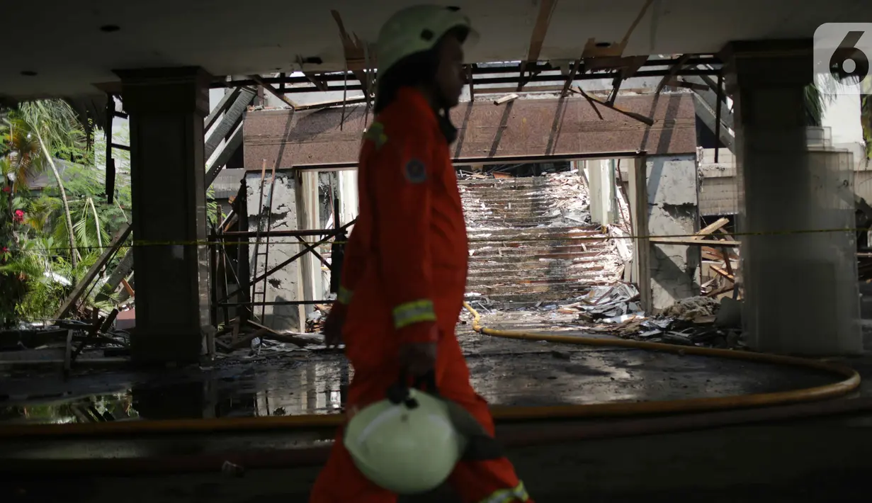Petugas pemadam kebakaran melintasi sisa kebakaran gedung Hailai di kawasan Ancol, Jakarta Utara, Selasa (5/11/2019). Bangunan itu dahulunya merupakan restoran dan klub namun saat ini dalam kondisi kosong dan dalam tahap pembongkaran. (Liputana6.com/Faizal Fanani)