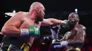 Tyson Fury (kiri) memukul Deontay Wilder pada pertandingan tinju kelas berat WBC di T-Mobile Arena, Las Vegas, Nevada, Amerika Serikat, 9 Oktober 2021. Tyson Fury mempertahankan sabuk juara dunia tinju kelas berat WBC usai mengalahkan Deontay Wilder pada ronde 11. (AP Photo/Chase Stevens)