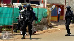 Tim Densus 88 Mabes Polri Indonesia berjaga di rumah terduga anggota jaringan teroris, Bekasi, Minggu (11/12). Densus 88 menangkap tiga orang terduga anggota kelompok teroris dan menemukan bom siap ledak. (Liputan6.com/Johan Tallo)