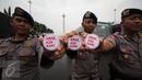 Petugas kepolisian menunjukan pin saat melakukan pengamanan di kawasan Monas, Jakarta, Selasa (18/4). Polda Metro Jaya dan Kodam Jaya mengerahkan 64.523 personel gabungan untuk mengawal Pilkada DKI 2017 putaran kedua. (Liputan6.com/Faizal Fanani)