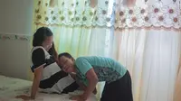 Jian, 17 tahun, sedang mendengarkan suara bayi di perut istrinya Mei (Muyi Xiao/CNN)