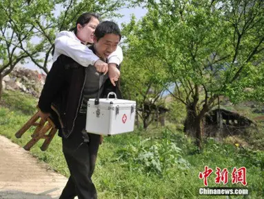 Li Juhong saat digendong seorang pria di Chongqing, Cina. Li Juhong mengalami  insiden tragis saat umurnya 4 tahun, ia mengalami sebuah kecelakaan mobil hingga mengharuskan kakinya diamputasi. (Chinanews.com)